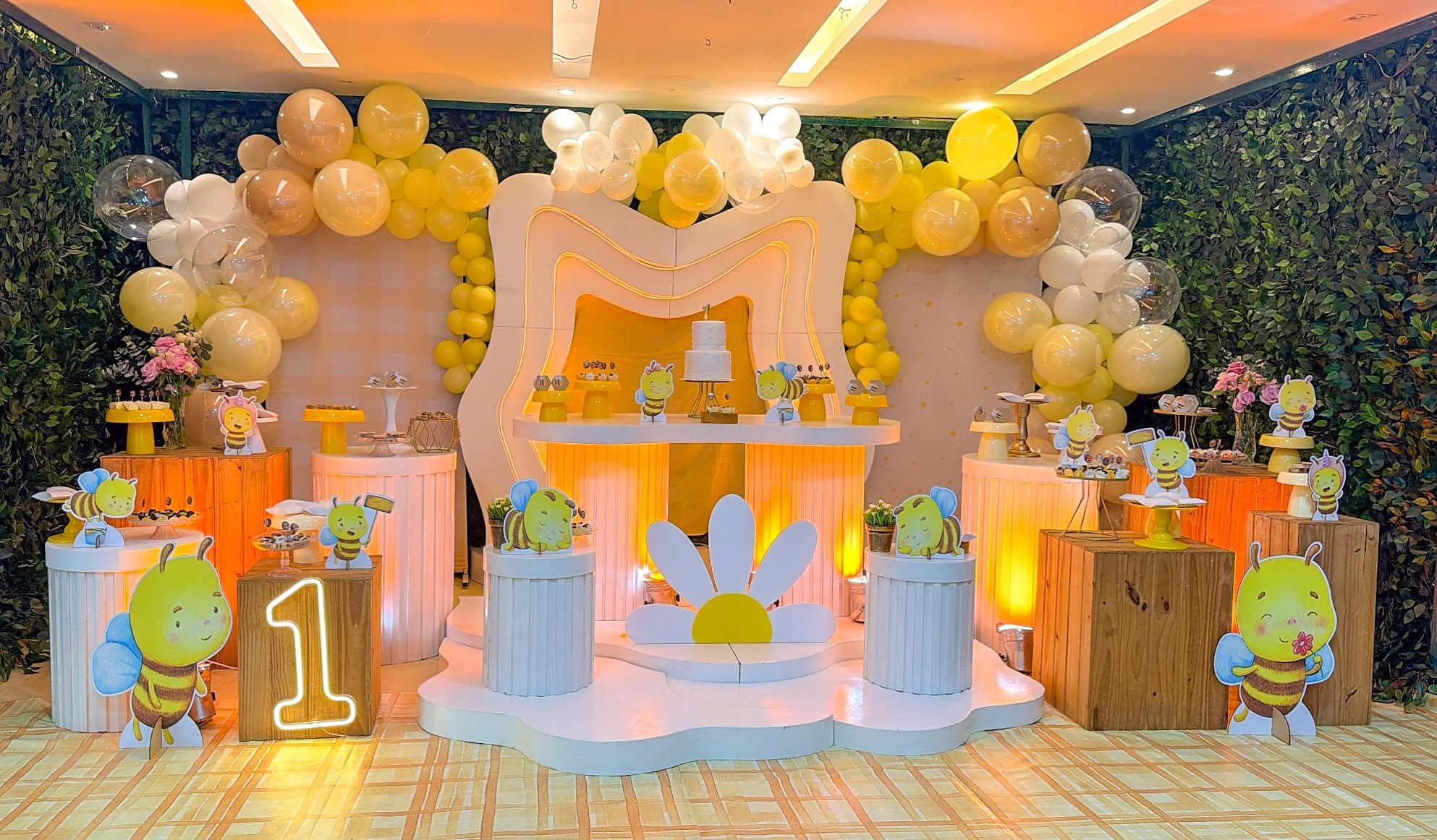 Mesa de primeiro aniversário com tema abelhinha, balões amarelos e margaridas